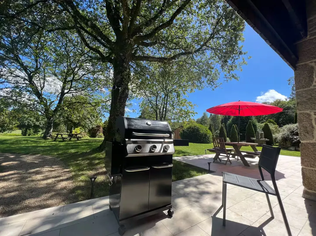 La terrasse de Maison Atlantique, sa table et son parasol, face au jardin